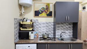 a small kitchen with a sink and a microwave at Studio - JONIKA in Tashkent +34 photos