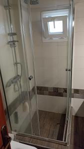 y baño con ducha y puerta de cristal. en Orestis Cozy Nest, en Platamonas