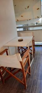 un tavolo con alcune sedie e un tavolo e sedie bianchi di Orestis Cozy Nest a Platamonas