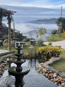 a water fountain in a garden with a view of a mountain at Estância Shangri-La in Santa Teresa