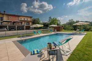 a swimming pool with chairs and umbrellas at Agriturismo Cascina Monchiero in Bra