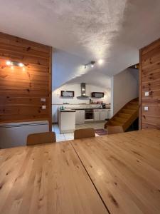 een woonkamer met een houten tafel en een keuken bij The Stable House Bourg d’Oisans -bike/hike/ski in Le Bourg-dʼOisans