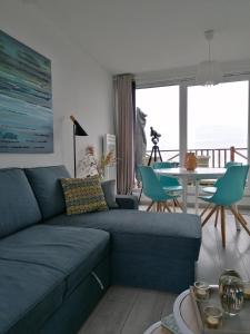 ein Wohnzimmer mit einem blauen Sofa und einem Tisch in der Unterkunft La Naturelle Duplex 90 in Wimereux