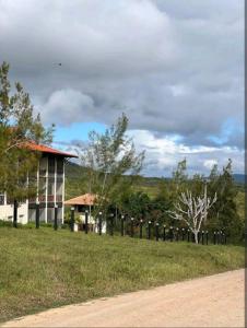 格雷夫森德的住宿－FLAT NA FAZENDA MONTE CASTELO GRAVATÁ - Pe，土路旁田野的房子