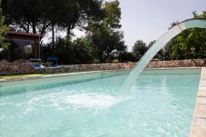 a water fountain in a swimming pool at trullo nonna netta con piscina idromassaggio e area giochi in Ceglie Messapica