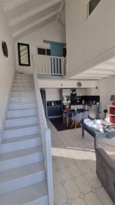 Un escalier mène à une cuisine et à un salon. dans l'établissement La Mangotine - Duplex à Saint François avec piscine, à Saint-François