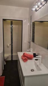 a white bathroom with a sink and a mirror at La Mangotine - Duplex à Saint François avec piscine in Saint-François
