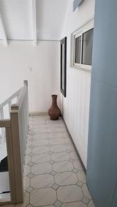 a hallway with a staircase and a vase on the floor at La Mangotine - Duplex à Saint François avec piscine in Saint-François