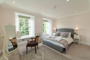 1 dormitorio con cama, escritorio y espejo en Beautiful Grade II Listed Apartments Sleeping 20, en Hexham