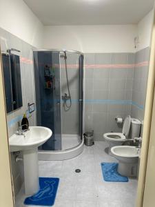 uma casa de banho com 2 WC, um chuveiro e um lavatório. em City Center Apartment Scutari em Shkodër