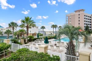 a resort with a pool and palm trees and a building at Indies 102 in Gulf Shores