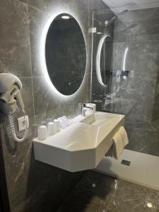 y baño con lavabo blanco y espejo. en Hotel 4 Estações, en Fátima