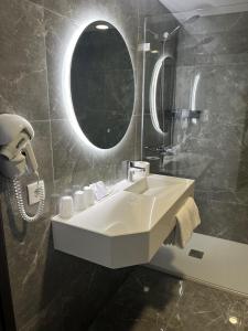 a bathroom with a white sink and a mirror at Hotel 4 Estações in Fátima