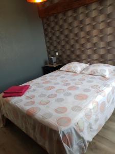 - un lit avec une couverture et des oreillers roses et blancs dans l'établissement Maison tout confort pour 4 à 6 dans village paisible, à Argenteuil-sur-Armançon