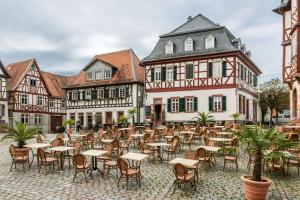 een lege binnenplaats met tafels en stoelen voor gebouwen bij Ferienwohnung historischer Markt in Heppenheim an der Bergstrasse