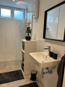 een witte badkamer met een wastafel en een spiegel bij Premium Ferienwohnung im Herzen der Kurstadt in Bad Neuenahr-Ahrweiler