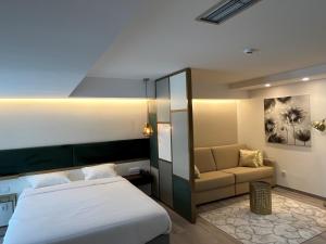 ファティマにあるHotel 4 Estaçõesのベッドとソファ付きのホテルルーム