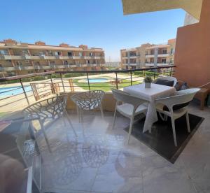 a patio with a table and chairs on a balcony at Sun Mirror Chalet El Sokhna in Ain Sokhna