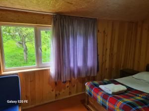 Schlafzimmer mit einem Bett und einem Fenster in der Unterkunft LIO in Glola