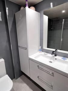 a bathroom with a sink and a toilet and a mirror at Duplex en résidence privée, piscine, vue mer panoramique in Alcossebre
