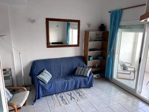 - un canapé bleu dans le salon avec un miroir dans l'établissement Duplex en résidence privée, piscine, vue mer panoramique, à Alcossebre