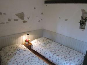 1 dormitorio con 2 camas y una mesa con flores en La Maison du Berger de La Chassagne, 