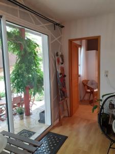 a sliding glass door in a room with a plant at Au Bosquet, chambre et salle de bains avec petit déjeuner à 600 m du centre dans un cadre calme et verdoyant in Salies-de-Béarn