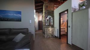 a living room with a leather couch and a mirror at Apartamento Naturaleza in Mosqueruela