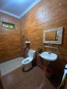 a bathroom with a toilet and a sink at La Tavisa Hotel Borobudur in Magelang