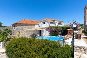 a house with a swimming pool in a yard at Holiday Home Bezic in Grohote