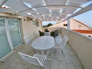 d'une terrasse avec une table et des chaises sur un balcon. dans l'établissement Fronte Mare S'Arena Scoada, à Putzu Idu