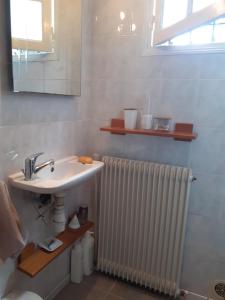 a bathroom with a sink and a radiator at Au Bosquet, chambre et salle de bains avec petit déjeuner à 600 m du centre dans un cadre calme et verdoyant in Salies-de-Béarn +25 photos