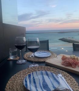 a table with two glasses of wine and a plate of food at SESIMBRA SOL in Sesimbra