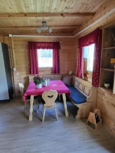 a dining room with a pink table in a cabin at Gartentraum am Bauernhof in Obdach