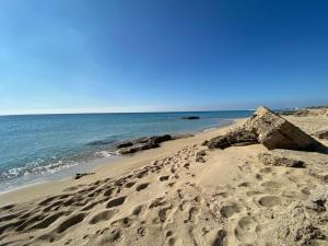 une plage avec des empreintes sur le sable et l'océan dans l'établissement Gemma Mediterranea, à Campomarino