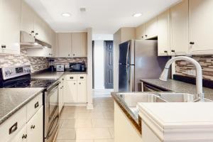 a kitchen with white cabinets and a stainless steel refrigerator at Sierra Lane 105 in Blue Mountains