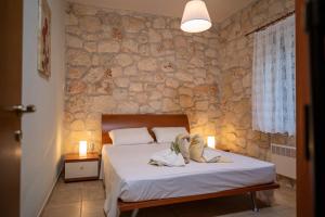 a bedroom with a bed and a stone wall at Jordan's Stone House in Siviri