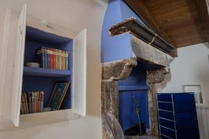 a room with a blue wall and a book shelf at B&B Dimora Cigno in Pietrapertosa