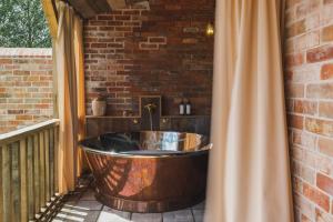 a wooden bath tub sitting on a patio at Outbuildings Dorset in Bridport