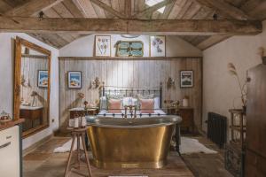 un ampio bagno con vasca e lavandino di Outbuildings Dorset a Bridport