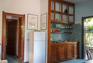 a kitchen with a white refrigerator and a sink at DomoMea - CàFè in Geremèas