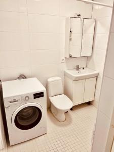 biała łazienka z pralką i toaletą w obiekcie Lovely 2-bed Flat In Stockholm w mieście Sollentuna