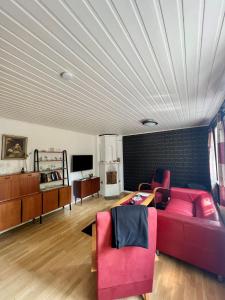 sala de estar con sofá rojo y sillas en STF Korrö B&B en Linneryd