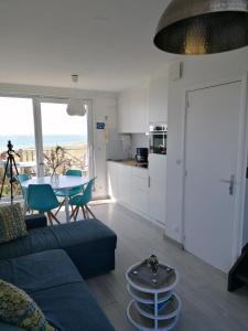 a living room with a blue couch and a table at La Naturelle Duplex 90 in Wimereux