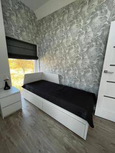 een slaapkamer met een bed en een muur bij Przy Kolonijnej in Ostrowo
