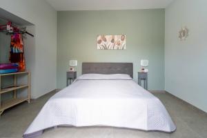 1 dormitorio con 1 cama blanca grande y 2 mesas en Affittacamere Parisi, en Villaggio Mosè