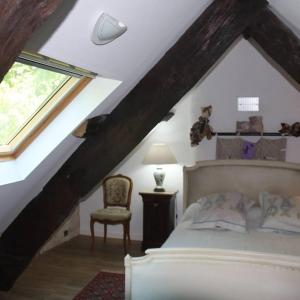 a bedroom with a bed and a chair in a attic at Le moulin des cavaliers in La Rouquette