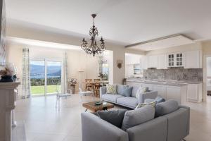 a living room with a couch and a kitchen at Villa Fantasia Isthmia in Isthmia