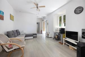 a living room with a couch and a tv at Holiday Home Bezic in Grohote