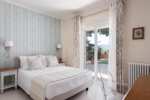 a bedroom with a bed and a large window at Villa Fantasia Isthmia in Isthmia